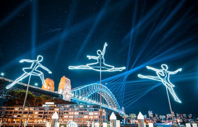 A Vivid Sydney light display in front of the Harbour Bridge.