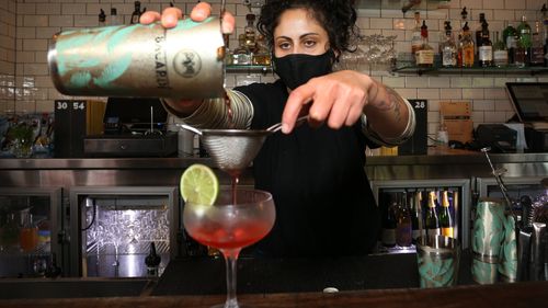 Bartender Rox prepares a cocktail during afternoon service at the Kings Cross Hotel on 'Freedom Day' in Sydney.
