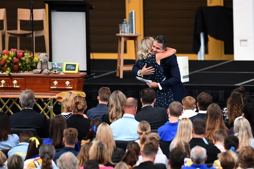 Dean Mercer's brother Darren hugs Reen Mercer during a memorial service for their brother and husband. (AAP)