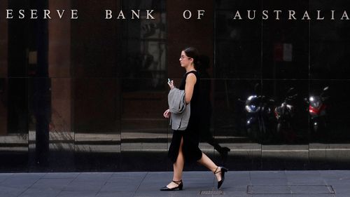 Une femme passe devant la Reserve Bank of Australia à Sydney.  La semaine dernière, la banque centrale australienne a abaissé son taux d'intérêt de référence d'un quart de point de pourcentage à un niveau record de 0,25 %, cherchant de toute urgence à atténuer les chocs économiques du nouveau coronavirus.