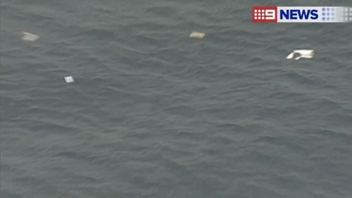 Aerial images showed debris and an oil slick on the surface of the water. (9NEWS)