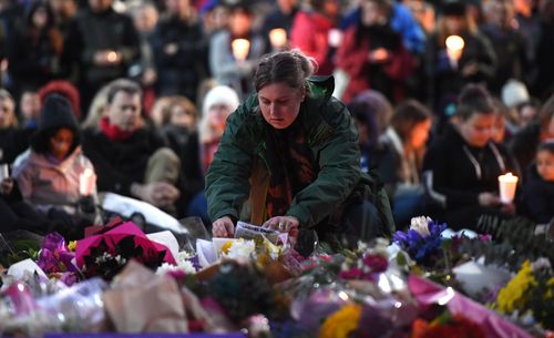 Another mourner lays a bouquet at the Reclaim Princes Park vigil. Picture: AAP