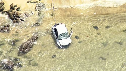 A woman and her child playing on the beach were hit by the car.