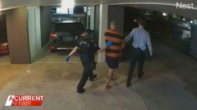 A man at a Gold Coast apartment complex, being led away by police.