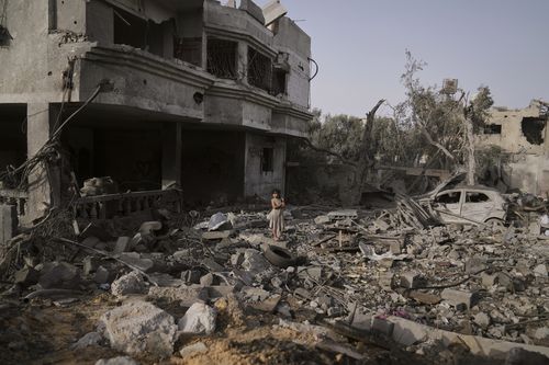 A Palestinian girl stands atop the rubble of the Al-Aimawi family's home that was destroyed by Israeli airstrikes in Al-Zawaideh, Gaza Strip, Tuesday, July 1, 2025. 