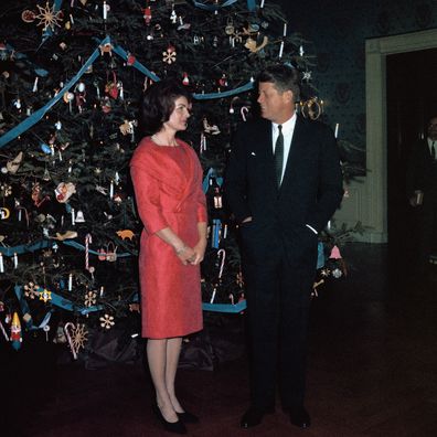 John F. Kennedy and Jackie Kennedy pose with the White House Christmas tree in 1961.