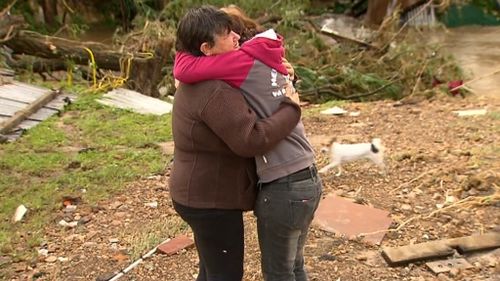 Reidents comfort others that have lost everything. (9NEWS)