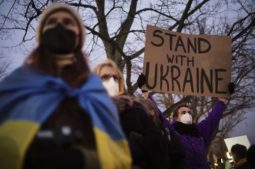 A man shows a poster in support of the Ukraine as he attends a demonstration along the street near the Russian embassy to protest against the escalation of the tension between Russia and Ukraine in Berlin, Germany, Tuesday, Feb. 22, 2022. (AP Photo/Markus Schreiber
