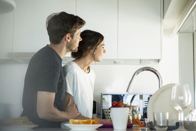 Couple smiling and looking outside the house