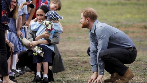 Il principe Harry e Meghan, duchessa del Sussex, sono abbracciati da Luke Vincent, 5 anni, al loro arrivo a Dubbo, in Australia, mercoledì 17 ottobre 2018. 