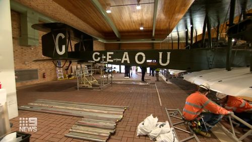 The Vickers Vimy is carefully being pulled apart so it can be transported and put back together again for the public to see inside the newly expanded terminal.