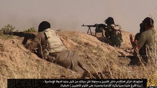 A photograph made available by the jihadist affiliated group Albaraka News allegedly shows ISIL fighters aiming at advancing Iraqi troops near the border between Syria and Iraq in 2014.
