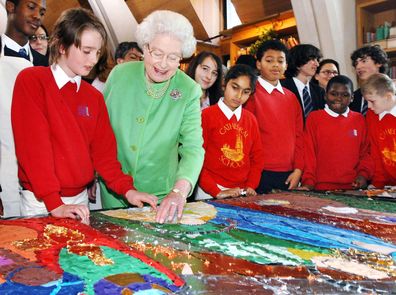 HM Queen Elizabeth II lays a few small mirror tiles around the head of baby Jesus on a nativity collage made by schoolchildren at Southwark Cathedral, December 7, 2006 in London, England. The children and their artwork feature in this year's Christmas broadcast from Her Majesty. The Queen's Christmas speech highlights how all religions stress the need to nurture and guide the young. In her December 25 message, the monarch will speak about the importance of the relationship between the generation
