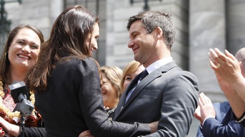 Prime Minister Jacinda Ardern, center left, embraces her partner Clarke Gayford after speaking in front of the parliament in Wellington last October. (AAP)