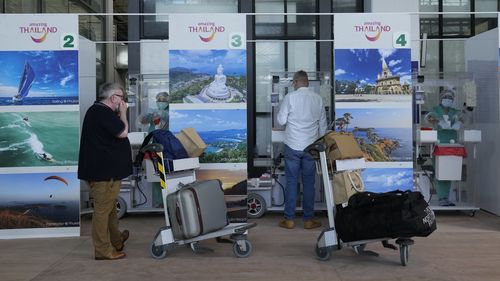 The first group of tourists prepare for a COVID-19 swab test after arriving at the Phuket International Airport in Phuket, southern Thailand in July. 