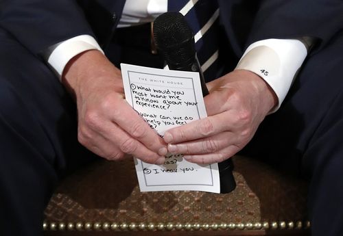 President Donald Trump was captured with cue cards wile talking to the survivors of the Florida shooting. (AAP)