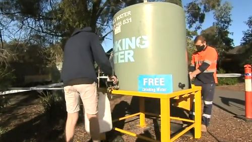 Melbourne residents fill up bottles at a safe water supply.