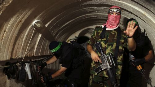 A Palestinian fighter from the Izz el-Deen al-Qassam Brigades, the armed wing of the Hamas movement, gestures inside an underground tunnel in Gaza in August 2014.