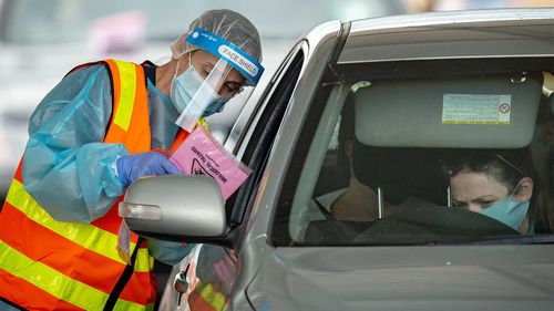 Medical professionals conduct COVID-19 tests at a drive through testing clinic in the Shepparton Sports Precinct.