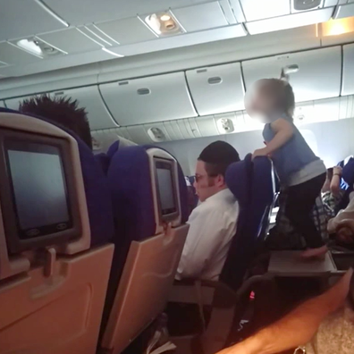 Plane passenger films child jumping on tray table during flight