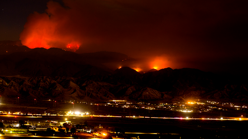 The Apple Fire burns behind mountains in Beaumont, Calif., Sunday, Aug. 2, 2020.  (AP Photo/Ringo H.W. Chiu)