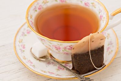 A high angle close up shot of a dainty cup full of english dark tea.
