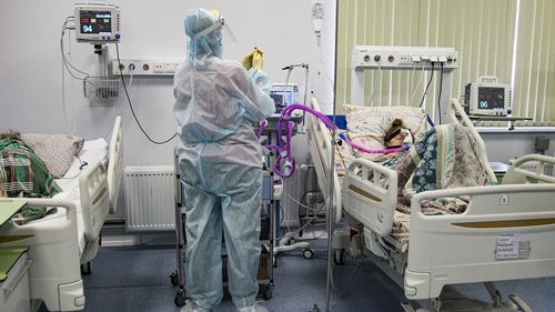 A medical worker wearing a special suit to protect against COVID-19 treats a patient at an ICU in Infectious Hospital No. 23 in Nizhny Novgorod, Russia, on Wednesday, Oct. 20, 2021. The low vaccination rate in Russia, where only about a third of the population is fully vaccinated, is causing concern as the country suffers a sharp rise in cases, setting records for infections and deaths nearly every day this month. (AP Photo/Roman Yarovitcyn)