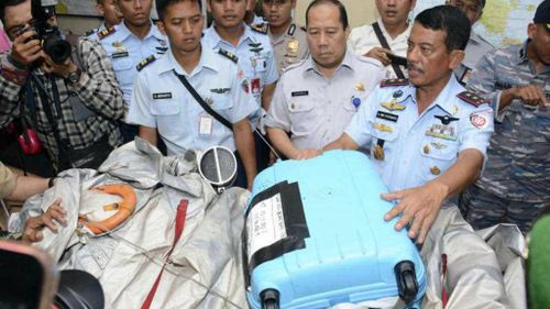 Indonesian Air Force commander Dwi Putranto shows debris including a suitcase found floating near where AirAsia flight 8501 disappeared. It was recovered by the Indonesian Navy. (AP)