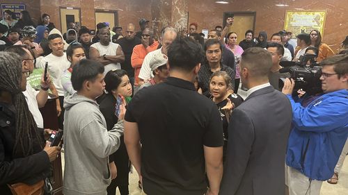 Utica Mayor Michael Galime, left, talks with the family members of a 13-year-old boy who was fatally shot by a police officer Friday night after a news conference on Saturday, June 28.