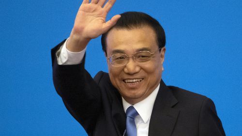 Then-Chinese Premier Li Keqiang waves during a press conference