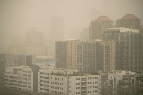 Haze and dust envelops buildings in Beijing, Friday, March 10, 2023. 