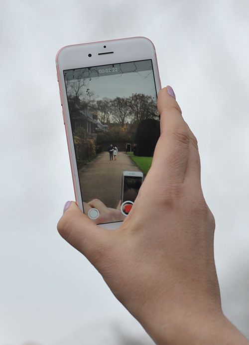 A woman records the couple after they made their engagement announcement. (AAP)