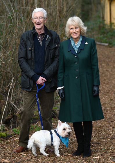 Camilla, Duchess of Cornwall, patron of Battersea Dogs and Cats Home and Battersea Ambassador Paul OGrady on a brief woodland walk with a rescue dog which is yet to be re-homed, during her visit to Battersea Brand Hatch Centre on February 2, 2022 in Ash, England 