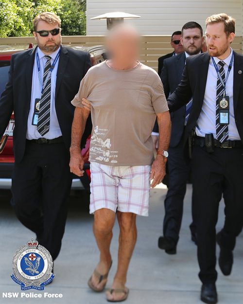 Detectives lead Chris Dawson away from a Gold Coast home this morning.