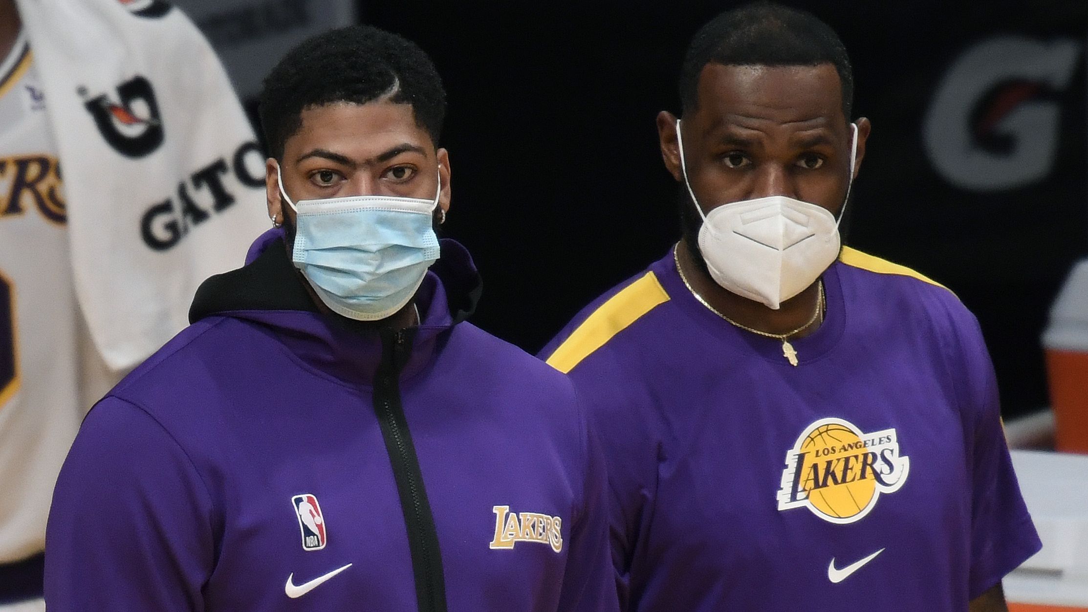 Anthony Davis and LeBron James of the Los Angeles Lakers watch a preseason game.