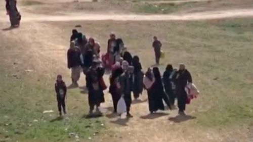 Civilians flee fighting near Baghouz, Syria.