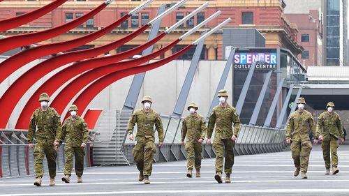 Members of the Australian Defence Force walk through Melbourne, which is now under stage four restrictions and a night curfew.