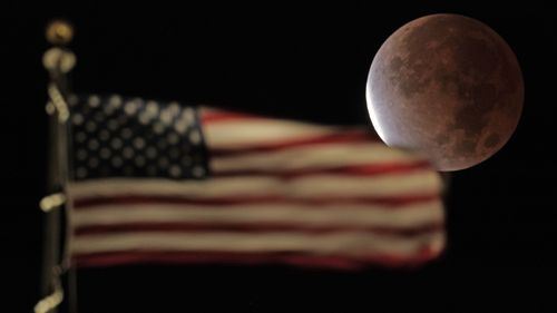 The earth's shadow covers the full moon during a partial lunar eclipse, Friday, Nov. 19, 2021, in Kansas City, Mo. (AP Photo/Charlie Riedel)