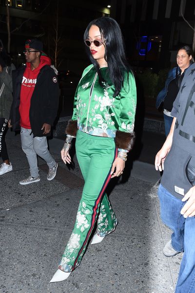 Rihanna takes the emerald silk tracksuit to sport couture
levels with a bold red lip and a white pointed heel.