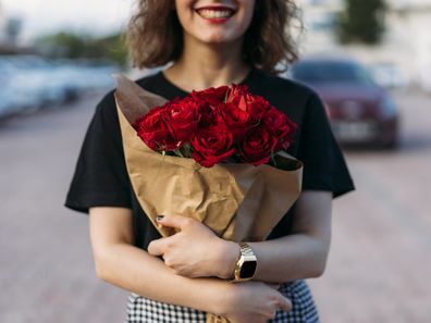 Young woman holding red roses