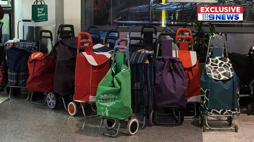 The tins were dumped in waiting trolleys, as the entire shelf was stripped.