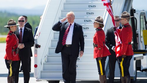 Mr Trump saluted Canadian Mounties as he was greeted at an airport at a military base in Quebec. Picture: CrowdSpark