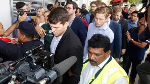 James Paver, center left, Nick Kelly, center with glasses, and Thomas Whitworth, center right, of the nine Australian men arrested are escorted to the Sepang Magistrate in Malaysia. (AAP)