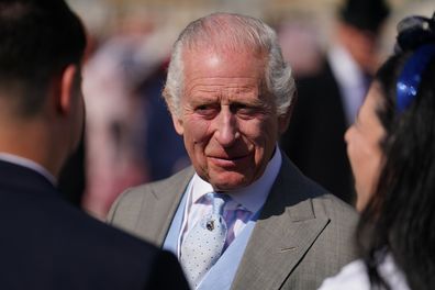 King Charles III speaks to guests attending a Royal Garden Party at Buckingham Palace on May 8, 2024 in London 