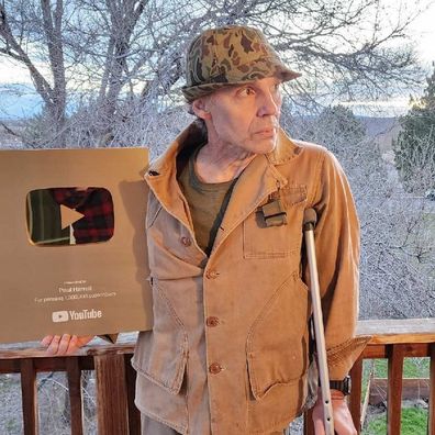 Paul Harrell standing proudly with his 1 million subscriber Play Button