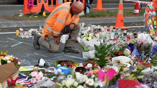 A worker grieves at a makeshift memorial at the Al Noor Mosque on Deans Rd in Christchurch.