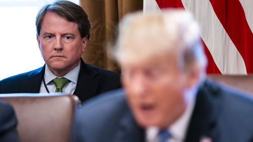 Don McGahn listens to Donald Trump speak.