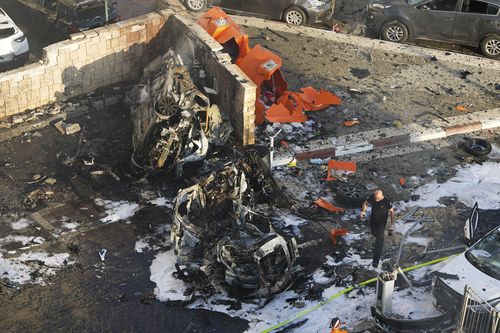 Israeli firefighters extinguish fire after a rocket fired from the Gaza Strip hit a parking lot in Ashkelon, southern Israel, Saturday, Oct. 7, 2023.