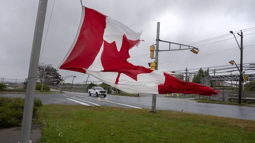 A Canadian flag waves in the high winds in Dartmouth, N.S. on Saturday, Sept. 24, 2022.    (Andrew Vaughan /The Canadian Press via AP)