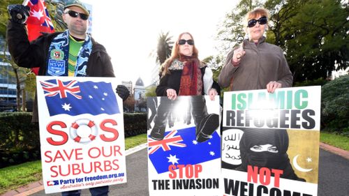 Far-right protesters held racist placards. (AAP)